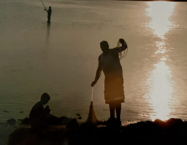Fisherman and young boy at dusk.